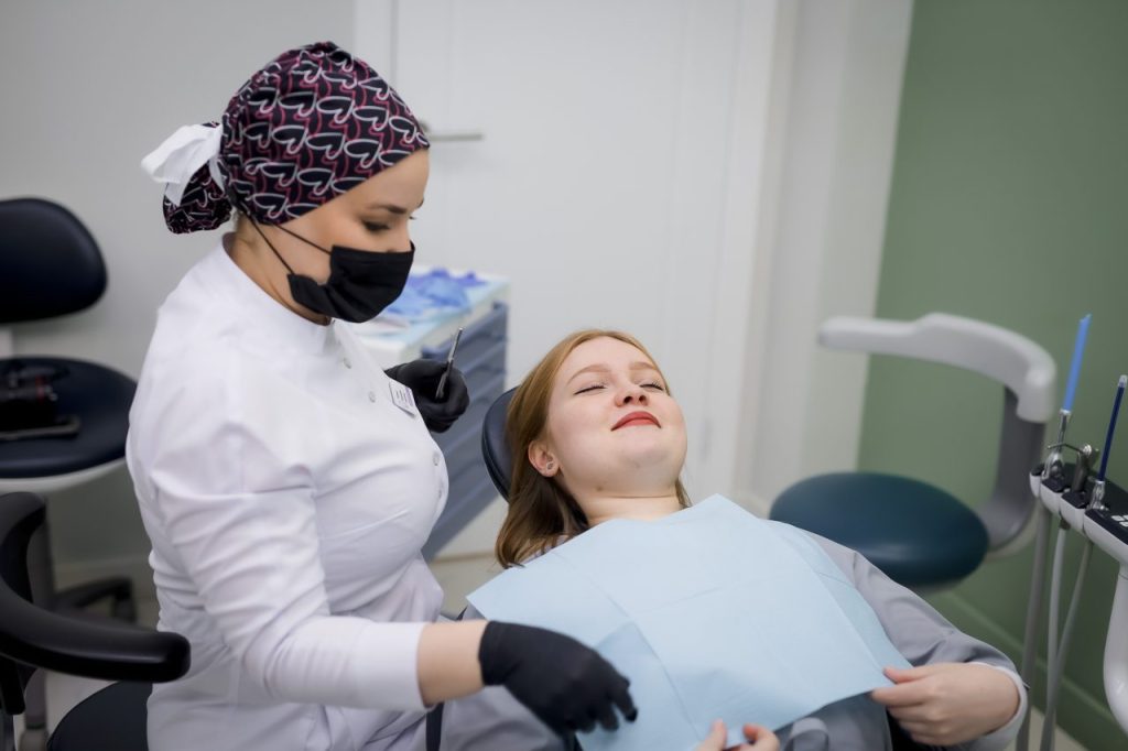 Ортодонт осматривает пациентку в кресле — ортодонт Амерханова Марема Хароновна, стоматология доктора Белоуса у метро Водный стадион
